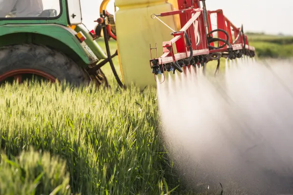 Ein Traktor versprüht Pestizide